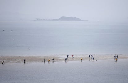 Personas mariscando durante la bajamar en Saint Malo. Las ciudades francesas de la costa norte del Atlántico se han preparado este fin de semana para la primera 'marea del siglo' desde 1997.