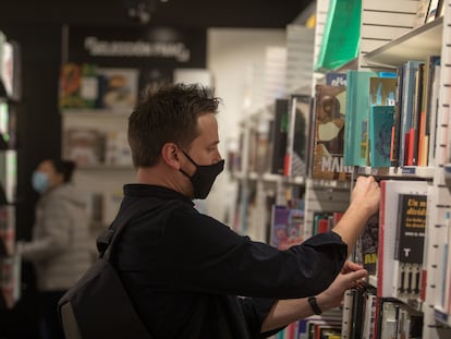 Un hombre busca en una estantería de una librería de Madrid.