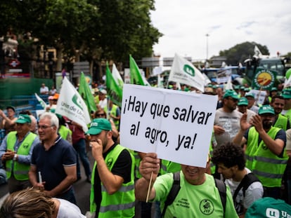 Un hombre con un cartel en el que se lee: 'Hay que salvar al agro ya!', durante una tractorada convocada por la Unión de Uniones de Agricultores y Ganaderos, frente al Ministerio de Agricultura, a 5 de julio de 2023, en Madrid (España).