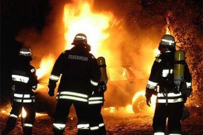 Los bomberos apagan un coche incendiado en Berlín a primeras horas del pasado día 9.