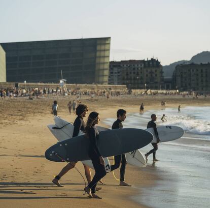 Surfistas en la playa de la Zurriola, en San Sebastián, con el Kursaal, de Rafael Moneo, al fondo.