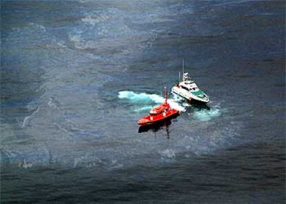 Dos embarcaciones participan en la limpieza de la mancha de hidrocarburo frente a la costa de Sitges, ayer por la mañana.