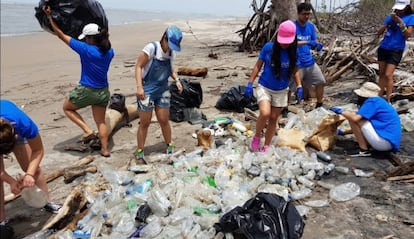 Un grupo de adolescentes limpia la playa de la Isla Tasajera en El Salvador.