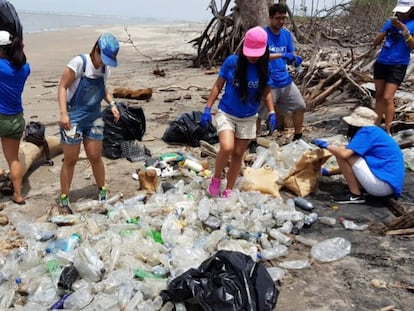 Un grupo de adolescentes limpia la playa de la Isla Tasajera en El Salvador.