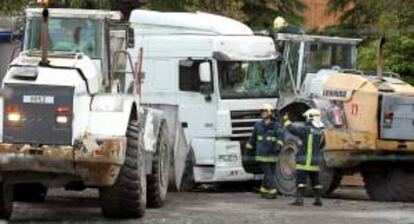 Un grupo de bomberos intenta liberar al conductor de un camión fallecido al quedar atrapado por su propio vehículo, en un accidente laboral en el municipio vizcaíno de Trapagaran. EFE/Archivo