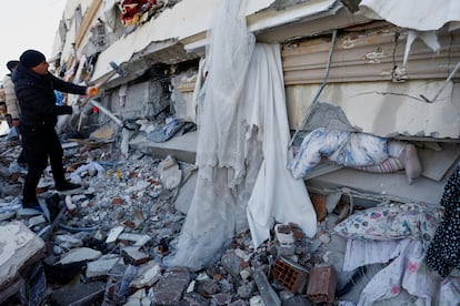 Una persona busca supervivientes entre los escombros de un edificio colapsado en Kahramanmaras (Turquía). 