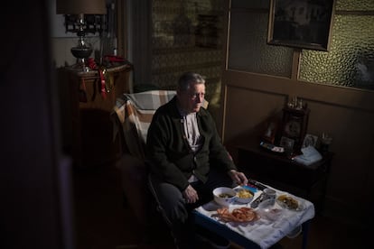 Álvaro Puig Moreno mira la televisión mientras come su cena de Nochebuena en su casa de Barcelona, el 24 de diciembre de 2020.