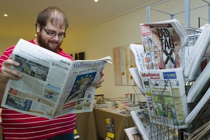 Un residente alemán, ojea la prensa alemana esta mañana en un quiosco de prensa de Mallorca.