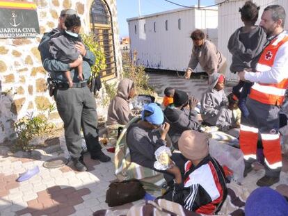 Guardia Civil y Cruz Roja atendiendo a algunos de los 45 inmigrantes llegados a Ceuta.