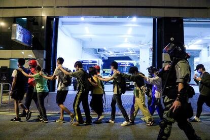 Manifestantes são escoltados pela polícia fora do campus da Universidade Politécnica de Hong Kong.