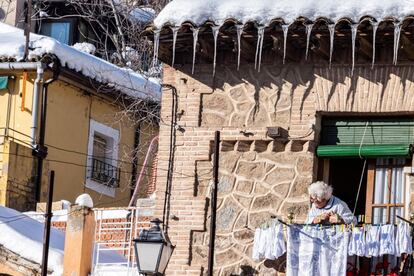 Una mujer observa desde su balcón las calles de Toledo, donde se empiezan a formar placas de hielo tras el paso de la borrasca 'Filomena', este lunes.
