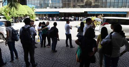 Personas en el exterior de oficinas de Manila, tras el doble terremoto.