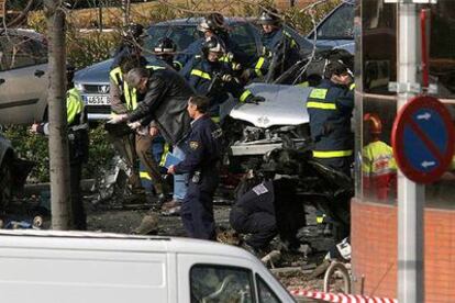 Bomberos y policías, junto al coche bomba que ETA hizo estallar el miércoles en Madrid.