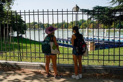 Dos mujeres miran las barcas del parque de El Retiro en Madrid.