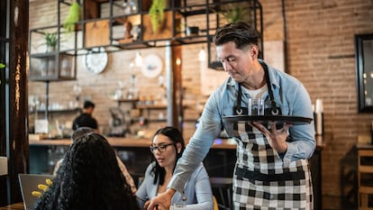 Un camarero sirviendo comida a los clientes en un restaurante.