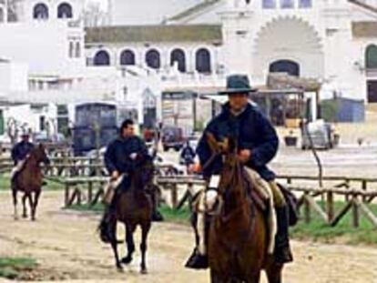 Tres romeros, ayer, en la aldea de El Rocío con sus caballos.