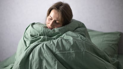 Una chica enredada en un edredón.
