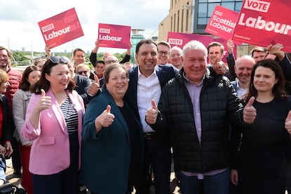 El líder del Partido Laborista en Escocia, Anas Sarwar (centro) celebra la victoria de su candidato Davy Russell (derecha) en Hamilton