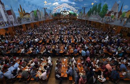 Una multitud de asistentes abarrota las mesas del recinto ferial de Theresienwiese durante la celebración del Oktoberfest en Múnich.