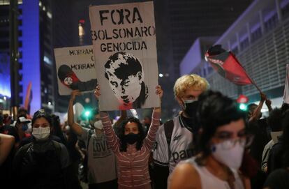 Una manifestante marcha con un cartel que dice "Fuera Bolsonaro genocida" en la avenida Paulista de São Paulo