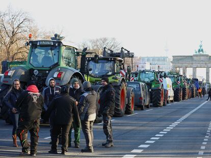 Decenas de gricultores alemanes protestan este lunes frente a la puerta de Brandeburgo, en el centro de Berlín, contra los recortes a los subsidios agrícolas que quiere acometer el Gobierno.