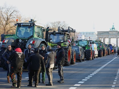 Decenas de gricultores alemanes protestan este lunes frente a la puerta de Brandeburgo, en el centro de Berlín, contra los recortes a los subsidios agrícolas que quiere acometer el Gobierno.