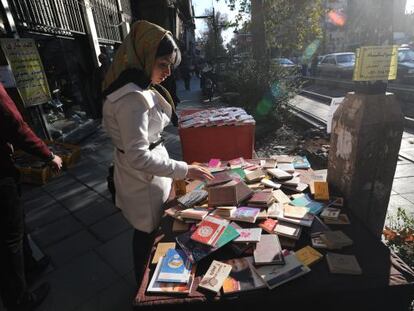 Una iraní hojea libros en Teherán.
