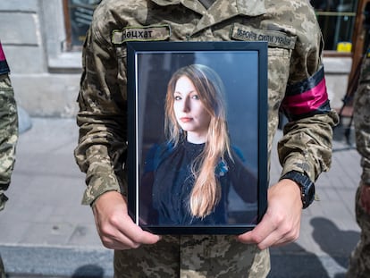 A soldier holds a photograph of writer Victoria Amelina during her funeral at the Church of St. Peter and Paul in Kyiv, July 5, 2023.
