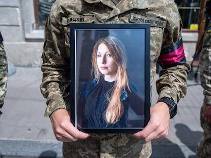 Un soldado sostiene una fotografía de la escritora Victoria Amelina durante el funeral que se celebró en la iglesia de San Pedro y San Pablo, en Kiev, el 5 de julio de 2023.
