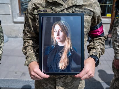 Un soldado sostiene una fotografía de la escritora Victoria Amelina durante el funeral que se celebró en la iglesia de San Pedro y San Pablo, en Kiev, el 5 de julio de 2023.