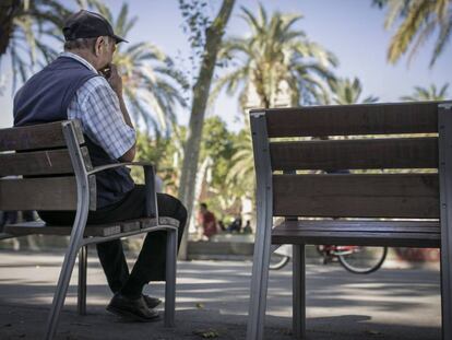 Un senyor gran descansa en un banc al carrer, a Barcelona.