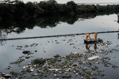 O eco-barcos recolhem os vertidos que se têm colado pela barreira na baía de Guanabara.