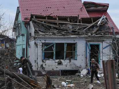 Local residents walk next to their house damaged during a Russian missile and drone strike in the city of Kamianske, Dnipropetrovsk region, Ukraine, March 29, 2024.