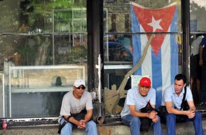Three men wait for the bus in Havana, Cuba.