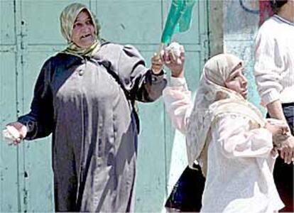 Mujeres palestinas lanzan piedras a soldados israelíes ayer en la ciudad de Nablús, en Cisjornia.