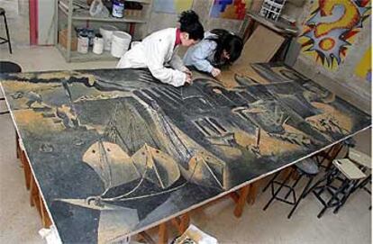 Dos alumnas de Bellas Artes trabajaban ayer en los últimos toques de la restauración del mural de Agustín Ibarrola.