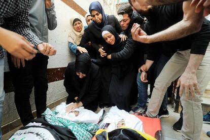 Familiares lloran ante los cuerpos de dos niños muertos por el ataque durante su funeral en Gaza, este martes.