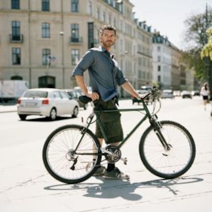 Un hombre lleva su bicicleta por Copenhague.