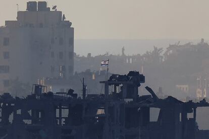 Una bandera israelí ondea en un edificio destruido en Gaza, esta tarde.