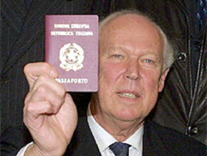 Víctor Manuel muestra su pasaporte italiano a los periodistas.