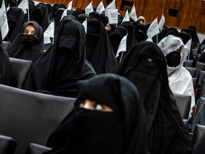 Grupo de mulheres levantam as bandeiras na faculdade de educação da Universidade de Cabul. 