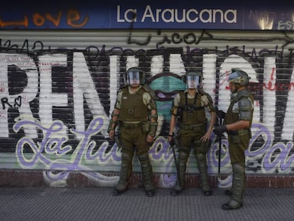 Policiais chilenos fazem a segurança de um supermercado fechado pelos protestos em Santiago.