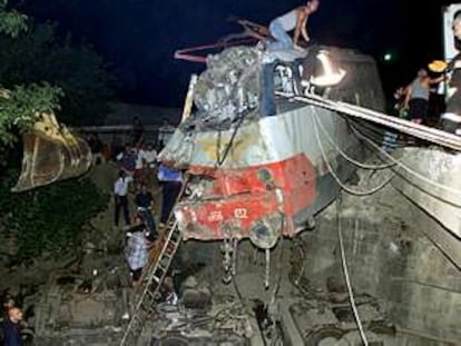 Varias personas buscan víctimas en el interior de la locomotora del tren accidentado.