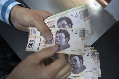 Un hombre cuenta billetes en una casa de cambio en Ciudad de México.