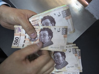 Un hombre cuenta billetes en una casa de cambio en Ciudad de México.