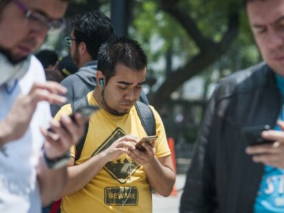Tres jóvenes usan sus teléfonos móviles en la Alameda Central, en Ciudad de México, en una fotografía de archivo.