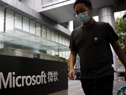 Un hombre pasa junto al logo de las oficinas de Microsoft en Pekín.