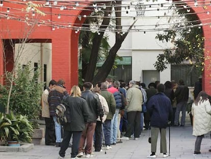 Un grupo de personas sin hogar aguarda para acceder al comedor del centro de acogida de San Isidro (Madrid).
