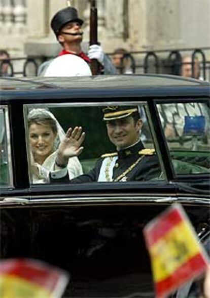 Los príncipes de Asturias saludan al público desde el Rolls-Royce en el que recorrieron las calles de Madrid.