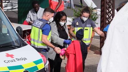 Un menor es atendido por policías y personal de Cruz Roja en el puerto de Santa Cruz de Tenerife, el lunes.